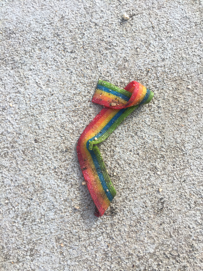 folded rainbow colored fruit roll-up on pavement
