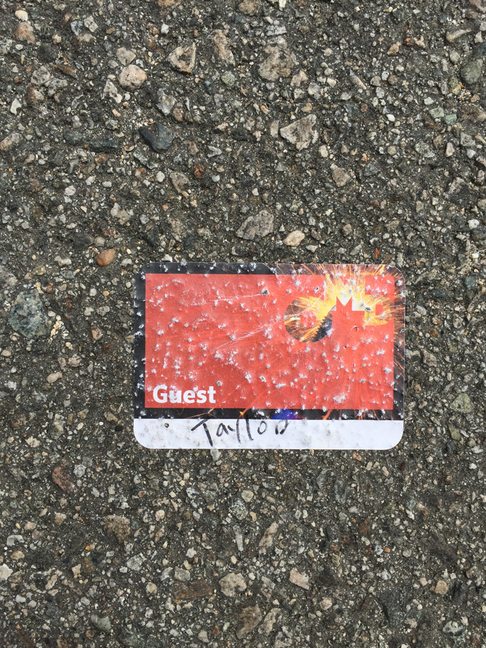 red sticker name badge that reads Taylor, stuck to street