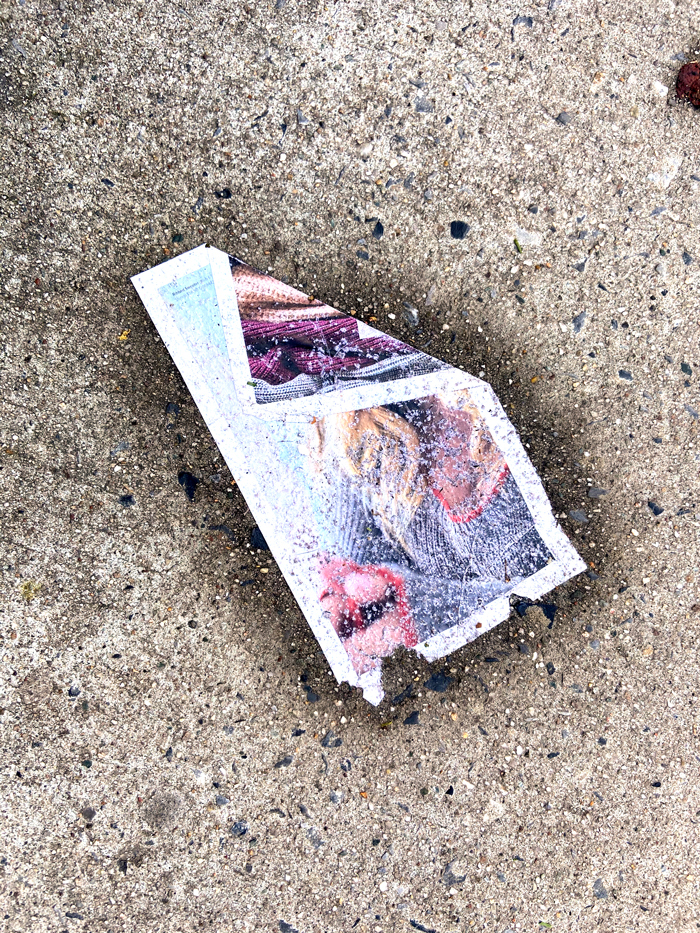 abstracted magazine page with lips and hair plastered over concrete