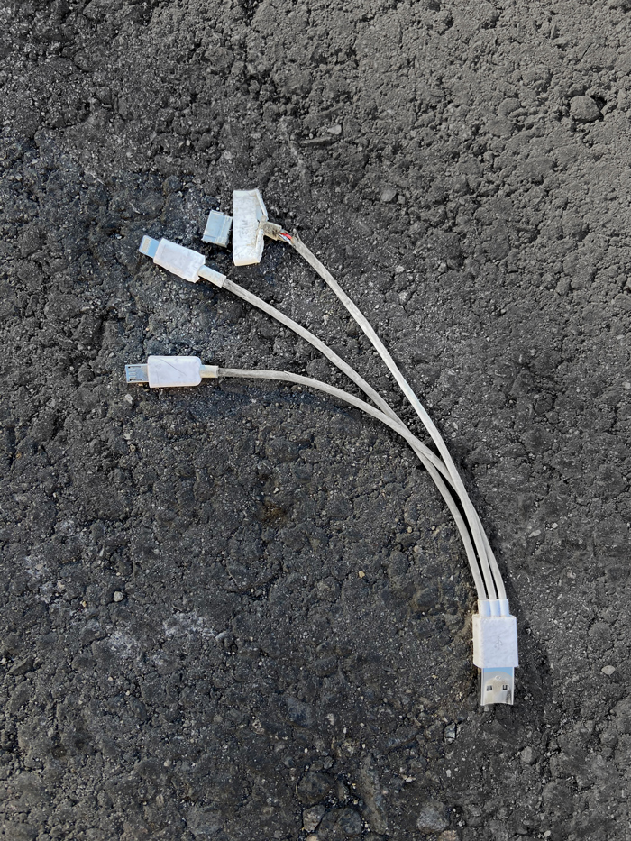 multi-prong phone charger adapter smashed on pavement