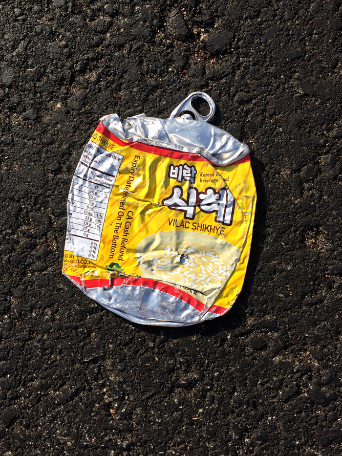 crushed can of Korean rice beverage on asphalt
