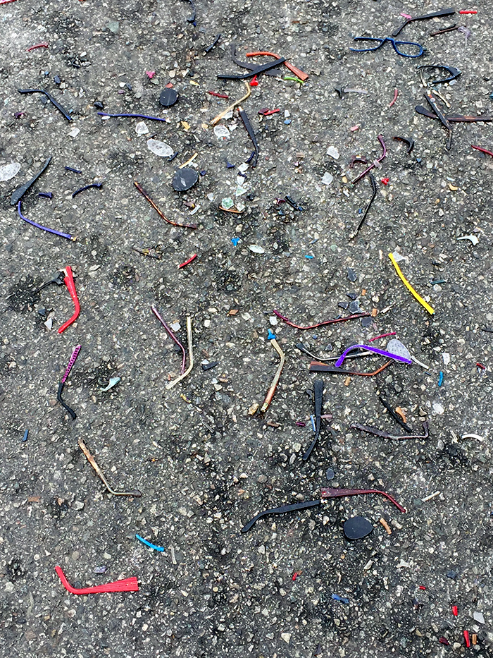 many colored plastic pieces of sunglasses scattered across road